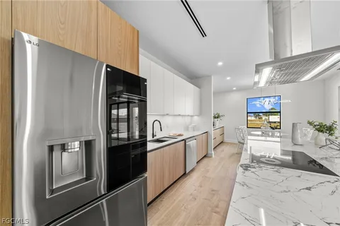 a large white kitchen with stainless steel appliances