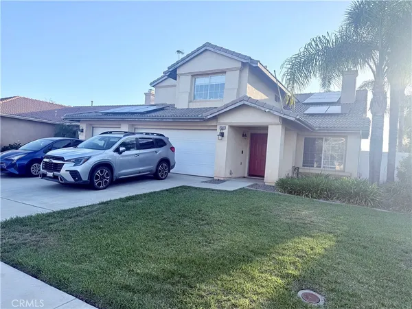 a front view of a house with a garden and parking space