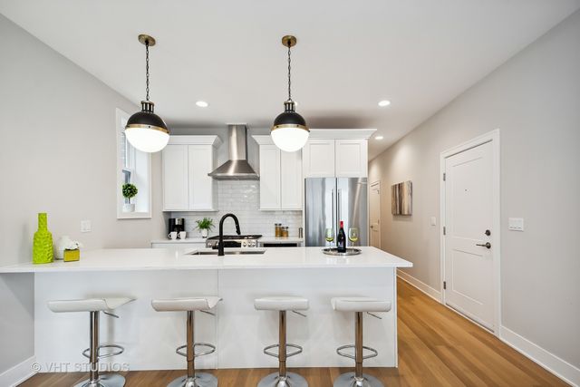 a kitchen with kitchen island a center island a sink stainless steel appliances and cabinets