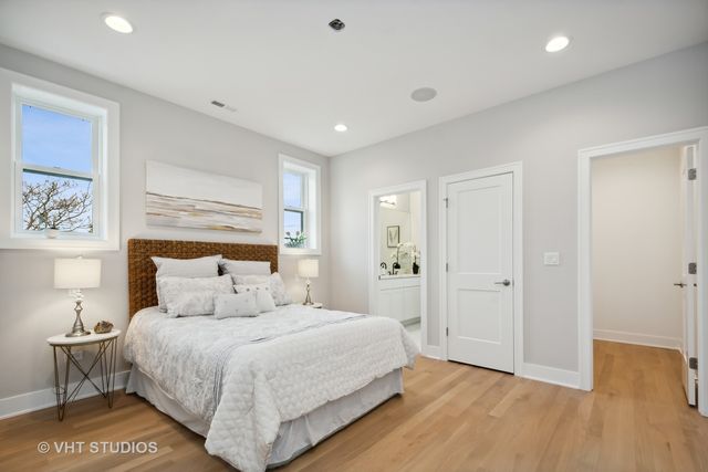 a bedroom with a large bed and wooden floor