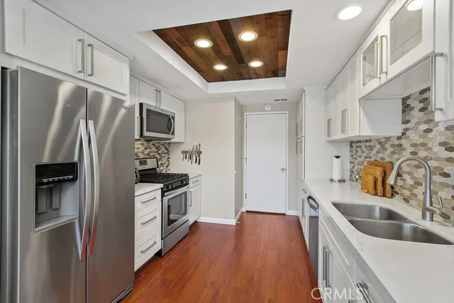 a kitchen with stainless steel appliances a refrigerator a sink a stove and cabinets