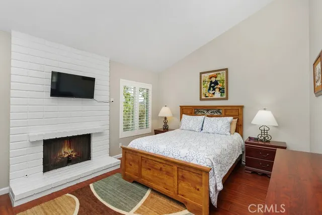 a bedroom with a bed a fireplace and a television
