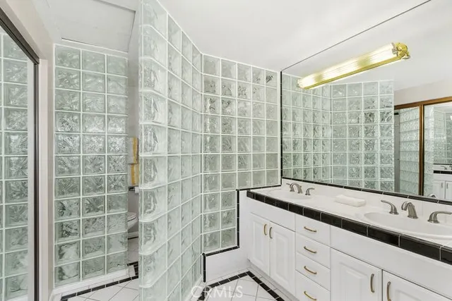 a bathroom with a double vanity sink and large mirror