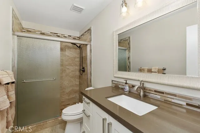 a bathroom with a sink toilet vanity and shower