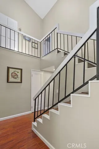 a view of staircase with lots of frames on wall and wooden floor
