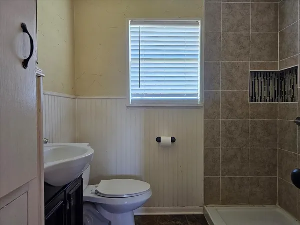 a bathroom with a sink a toilet and shower