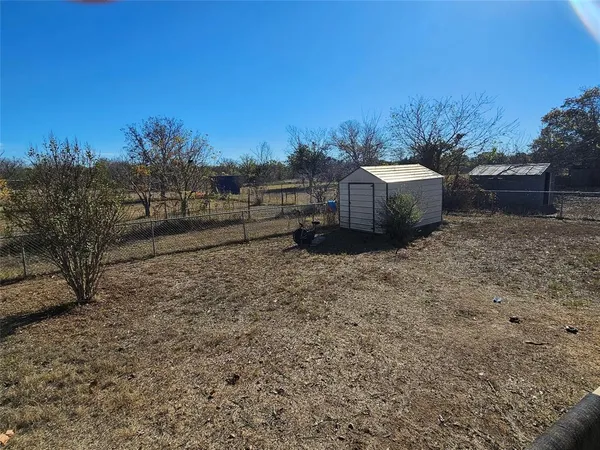 a view of a yard with wooden fence