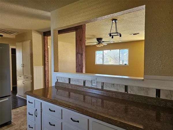 a bathroom with a granite countertop sink a large mirror and a window
