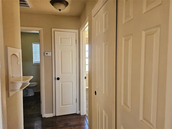a view of a bathroom from a hallway with toilet and sink