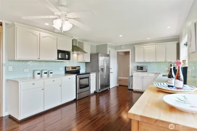 a kitchen with white cabinets and stainless steel appliances