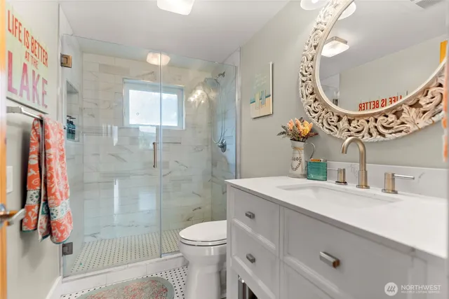 a bathroom with a sink a toilet and shower