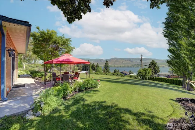 a view of a swimming pool with a table and chairs under an umbrella