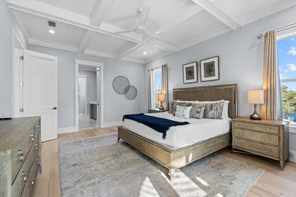 a spacious bedroom with a bed a window and dresser