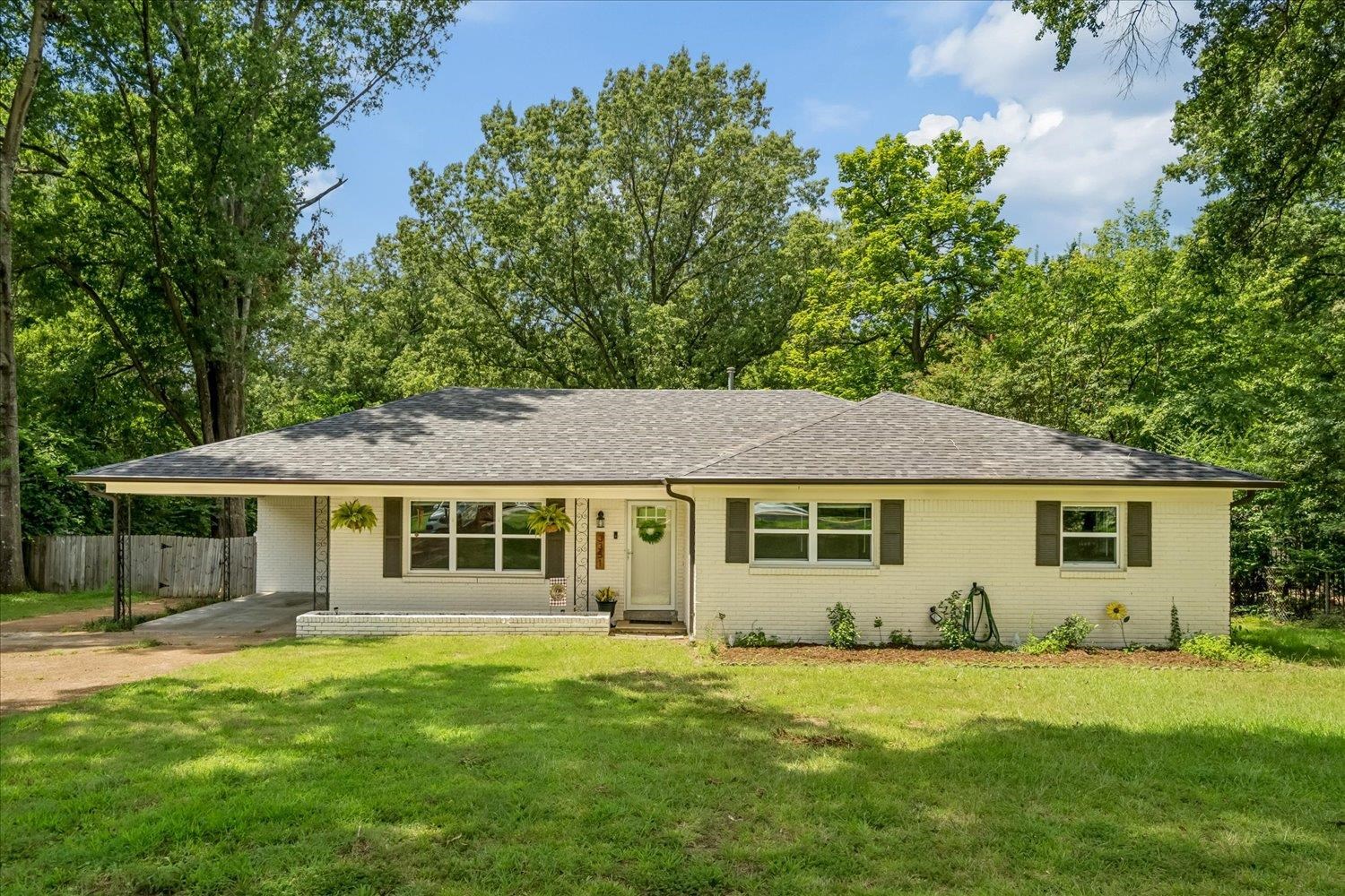 Single-story residence featuring a carport, a gabled roof, and a front facade with multiple windows