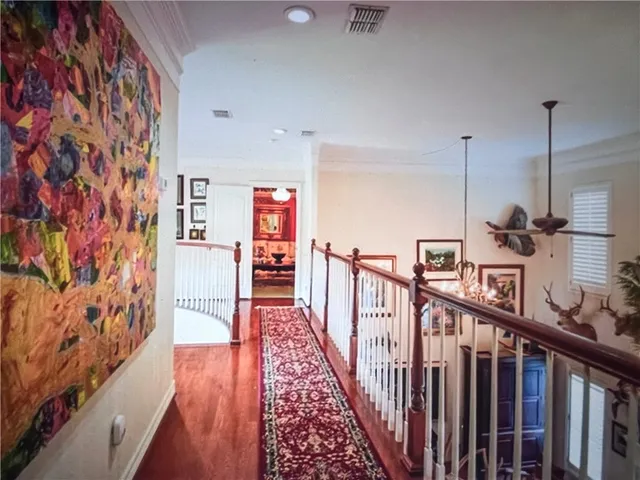 a view of a hallway with wooden floor and stairs
