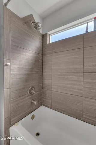 a bedroom with a bed and a refrigerator