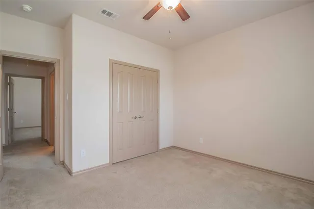 an empty room with a ceiling fan and a window
