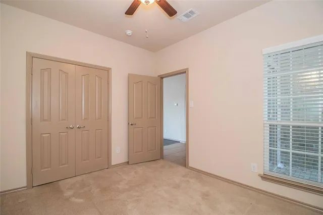 an empty room with chandelier fan