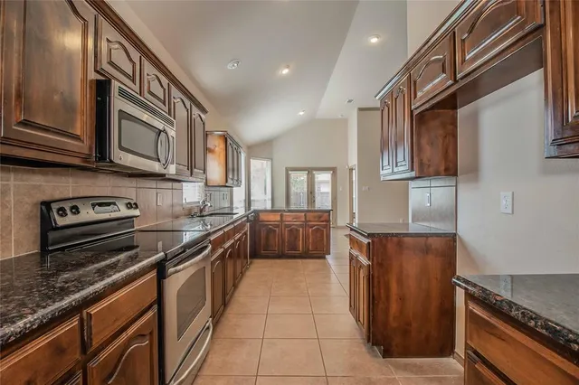 a kitchen with stainless steel appliances granite countertop a stove and a sink