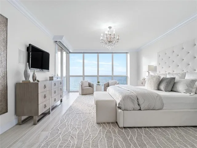 a spacious bedroom with a bed and a flat screen tv