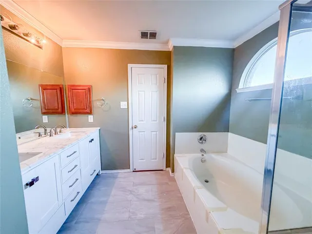 a bathroom with a tub sink and mirror