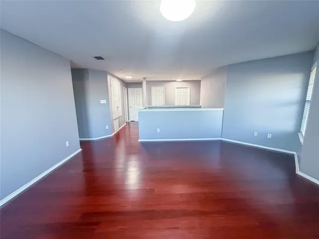 a view of empty room with wooden floor