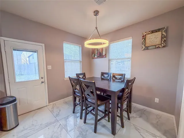a view of a dining room with a table and chairs