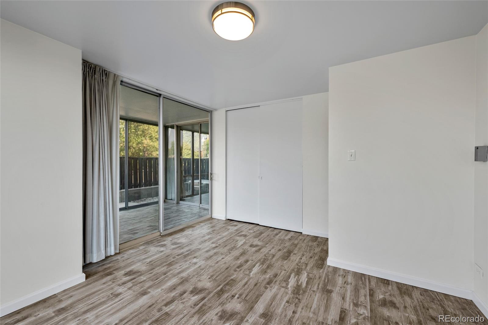 3100 East Cherry Crk N Drive, Unit 108 Denver, CO 80209 - Photo 13 of 25 an empty room with wooden floor and windows