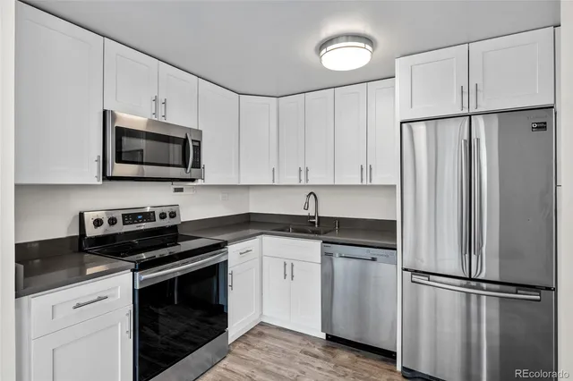 a kitchen with white cabinets and stainless steel appliances
