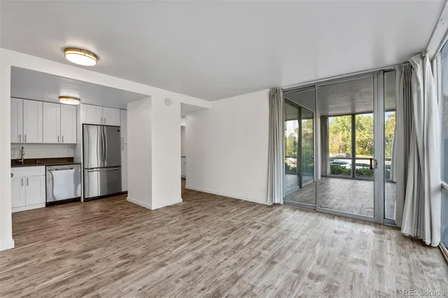 a view of kitchen with refrigerator and wooden floor