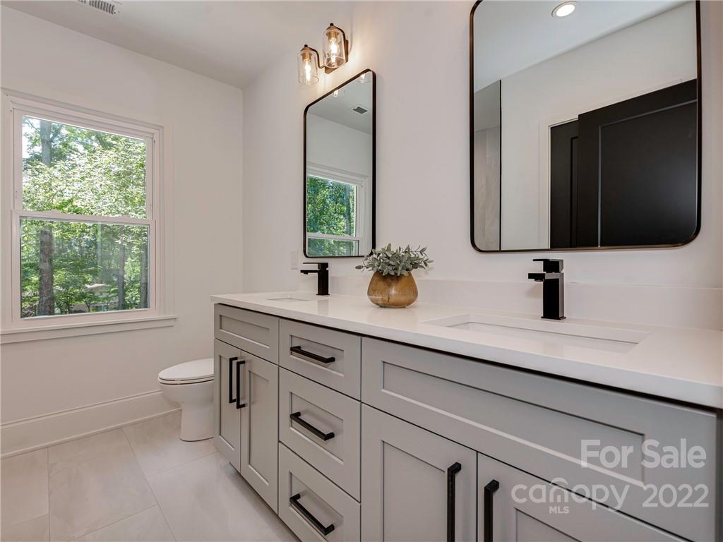 523 Robmont Road Charlotte, NC 28270 - Photo 18 of 26 a bathroom with a double vanity sink toilet and mirror