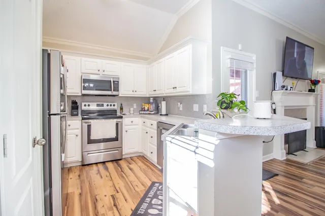 a kitchen with granite countertop a sink stove and refrigerator