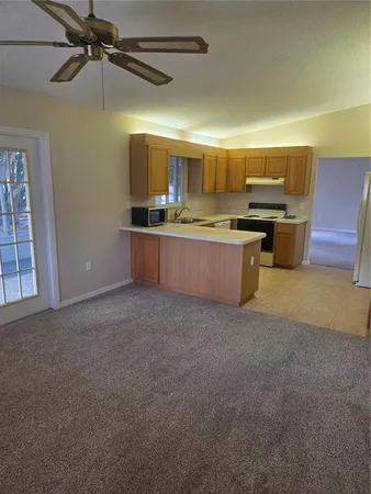a kitchen with stainless steel appliances kitchen island a large counter top a stove and a refrigerator