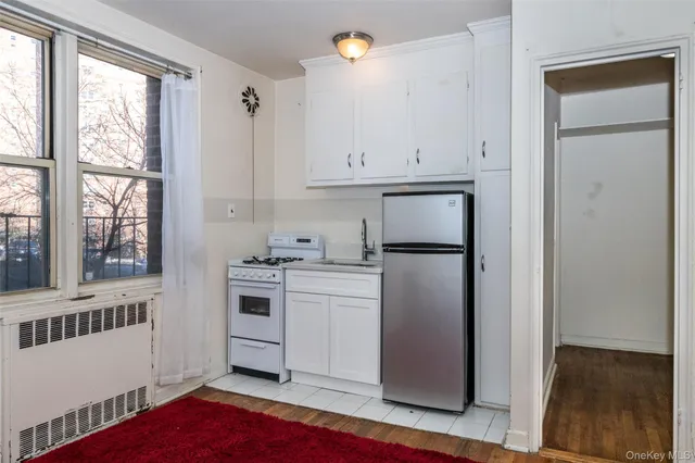 a kitchen with a refrigerator sink and cabinets