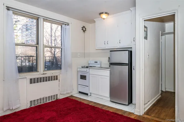 a kitchen with white cabinets and a refrigerator
