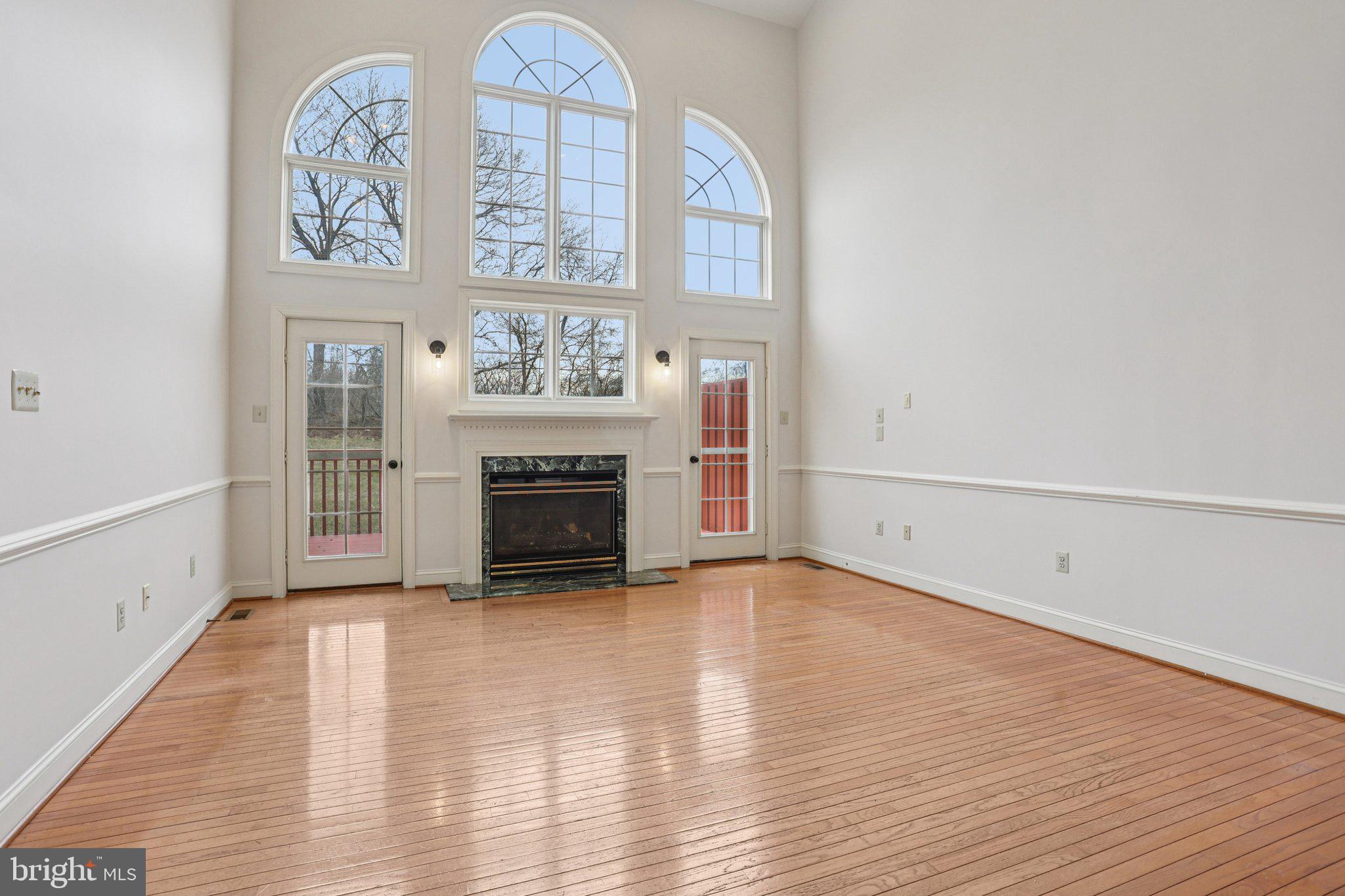 82 Granville Way Exton, PA 19341 - Photo 4 of 51 an empty room with wooden floor a fireplace and windows