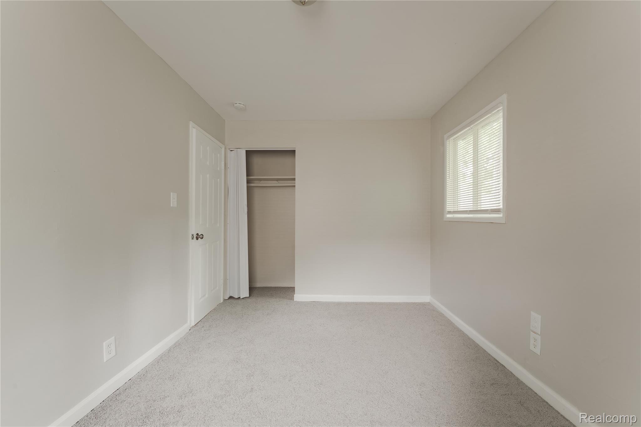 93 West Princeton Avenue Pontiac, MI 48340 - Photo 17 of 31 Carpeted room with neutral wall tones, white trim, and a window with horizontal blinds