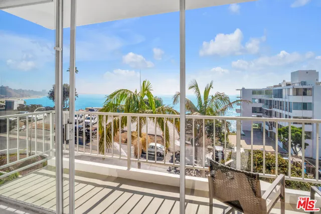 a view of balcony with a couple of palm trees