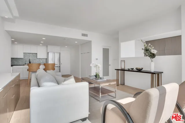 a living room with furniture and kitchen view