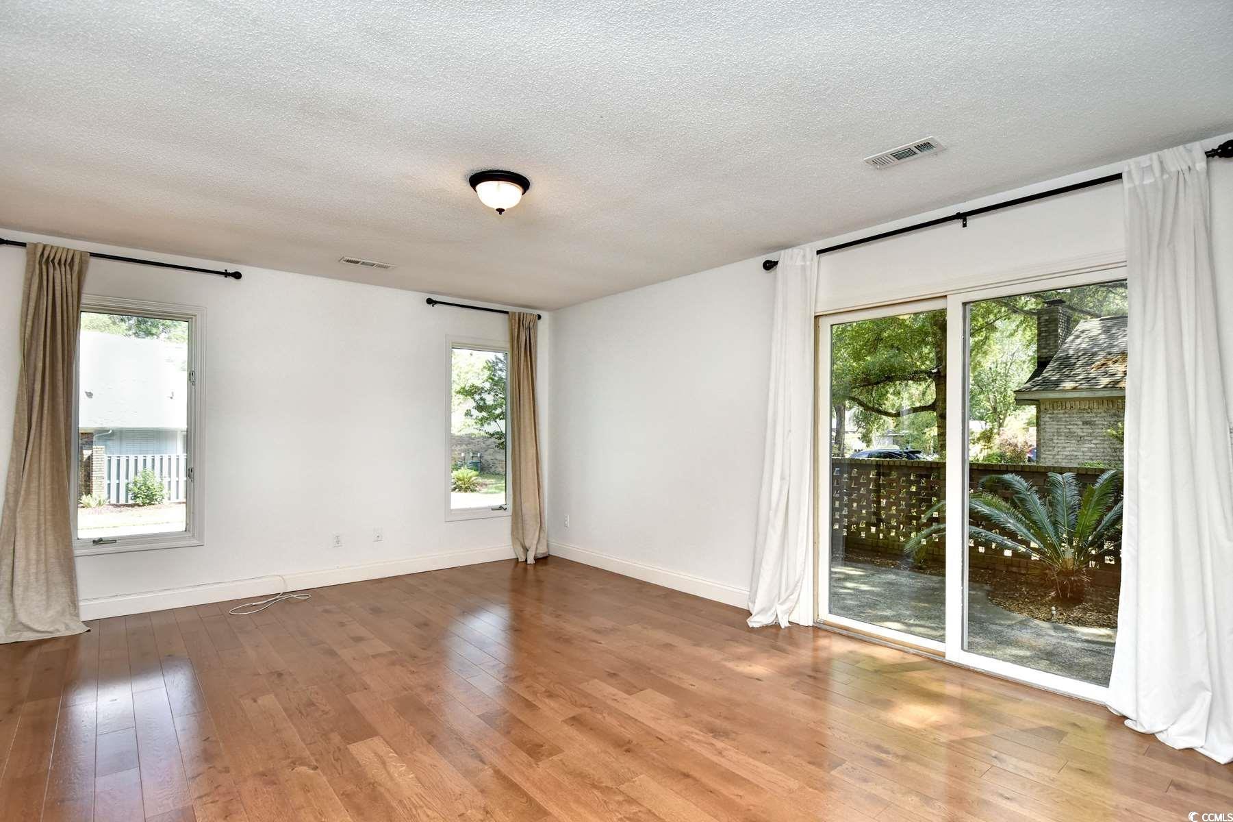 816 Kittiwake Lane Murrells Inlet, SC 29576 - Photo 12 of 25 Empty room with a textured ceiling, wood-type floo