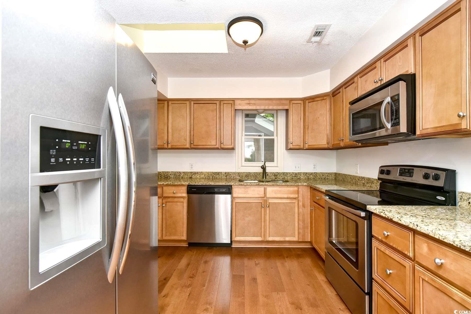 816 Kittiwake Lane Murrells Inlet, SC 29576 - Photo 9 of 25 Kitchen with light stone countertops, a textured c