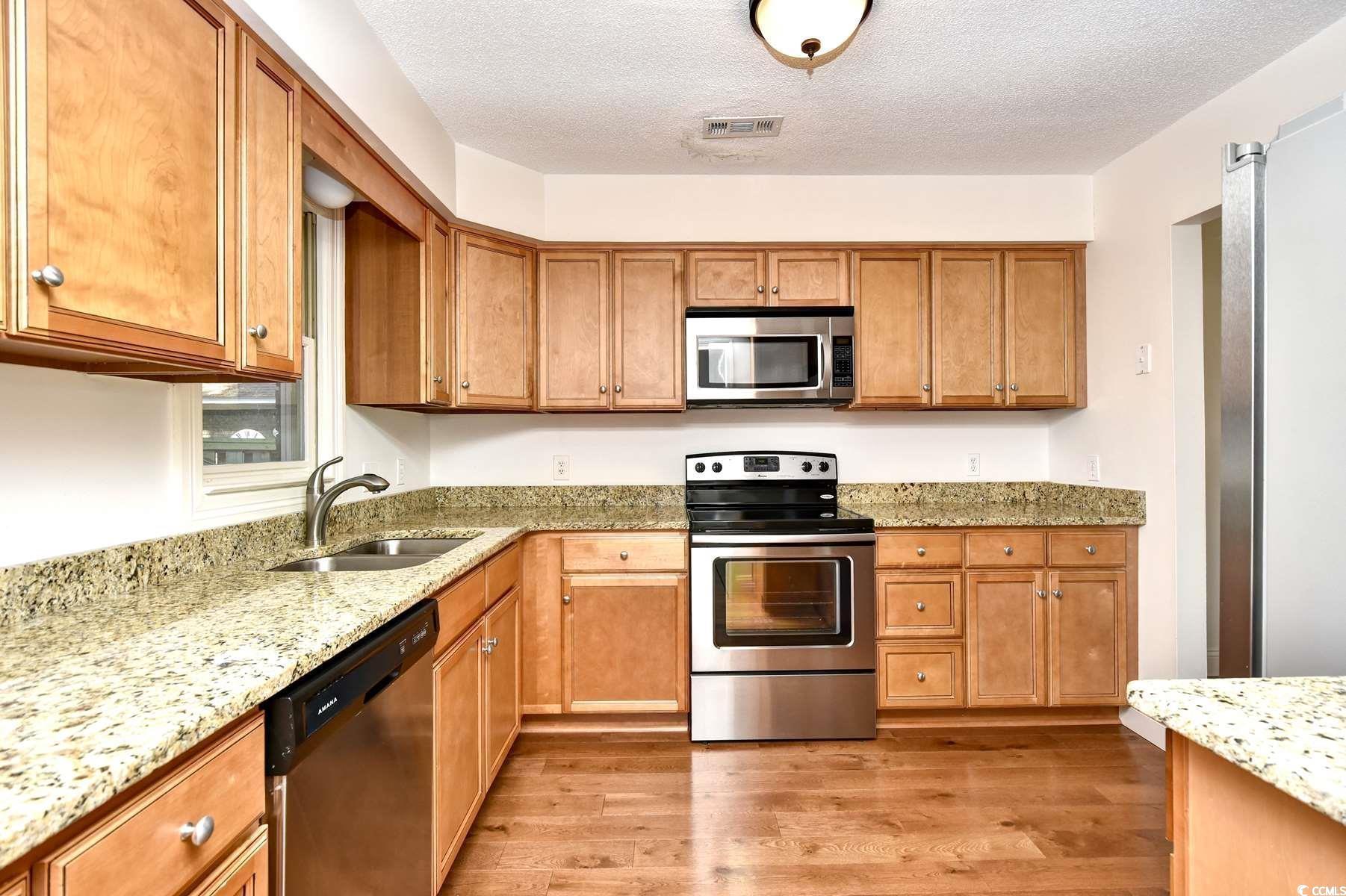 816 Kittiwake Lane Murrells Inlet, SC 29576 - Photo 10 of 25 Kitchen with light stone countertops, visible vent
