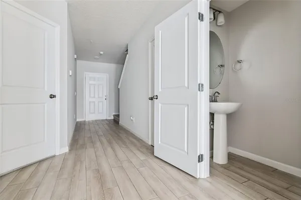 a view of a hallway with wooden floor and staircase