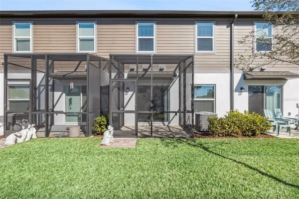 a view of a house with brick walls and a yard with plants