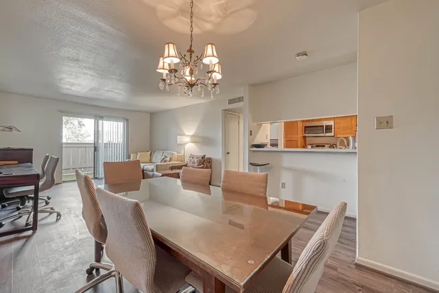 a view of a dining room with furniture and chandelier