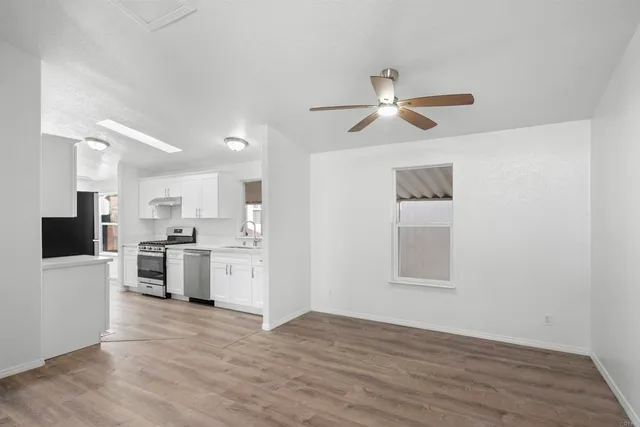 a view of kitchen with wooden floor and electronic appliances