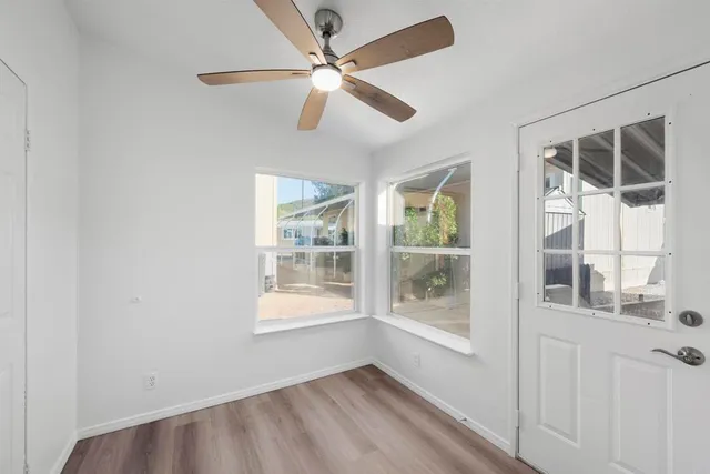 an empty room with windows and fan