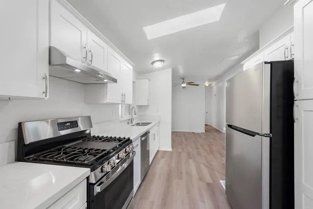 a kitchen with stainless steel appliances granite countertop a refrigerator and a stove