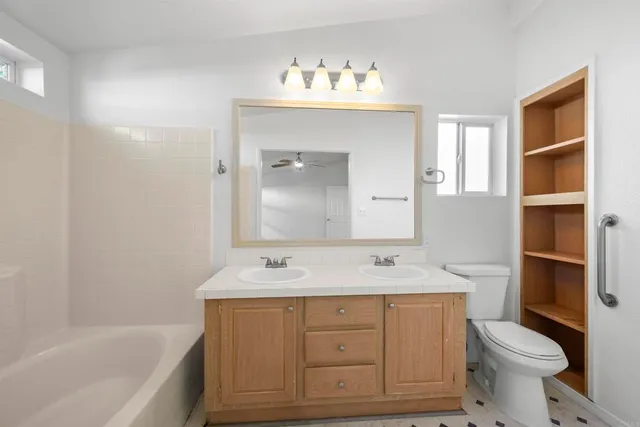 a bathroom with a sink toilet vanity and bathtub