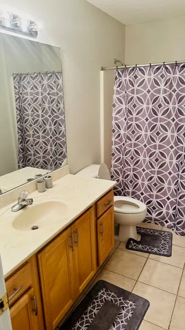 a bed sitting in a bedroom next to a window and a chandelier